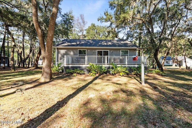 single story home featuring a front yard and a deck