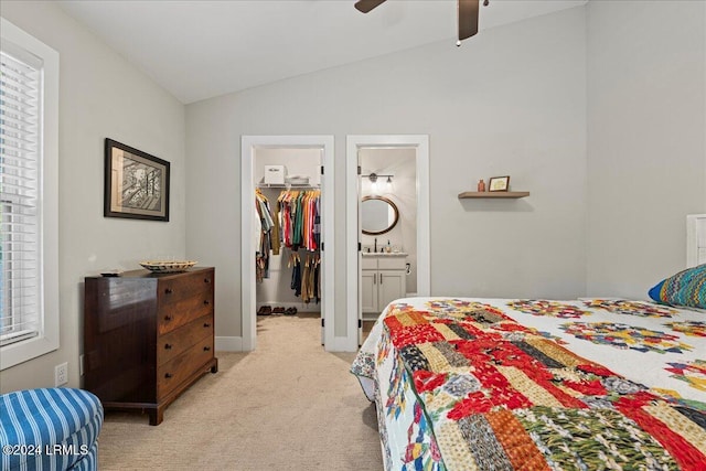 carpeted bedroom with lofted ceiling, ceiling fan, connected bathroom, a spacious closet, and a closet