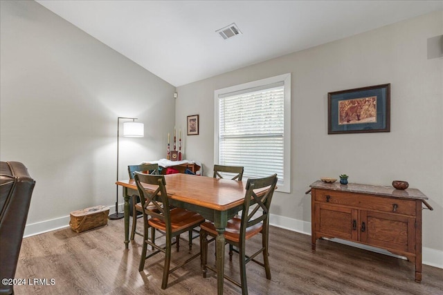 dining area featuring lofted ceiling and dark hardwood / wood-style flooring