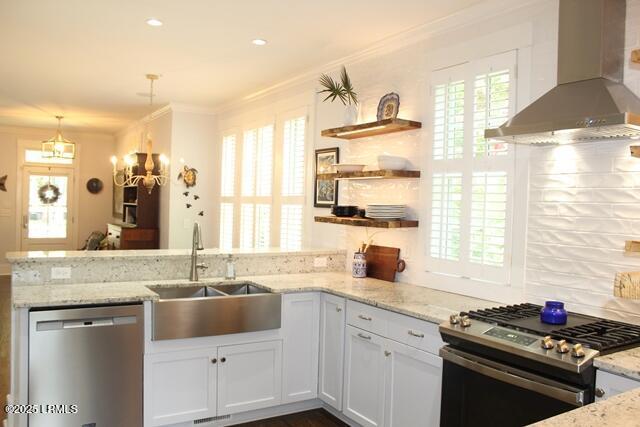 10 Hayek St, Beaufort, SC 29907 - kitchen featuring wall chimney exhaust hood, appliances with stainless steel finishes, crown molding, light stone countertops, and a peninsula