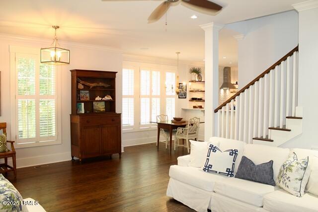 10 Hayek St, Beaufort, SC 29907 - living room featuring dark wood-style floors, a ceiling fan, stairway, crown molding, and a chandelier