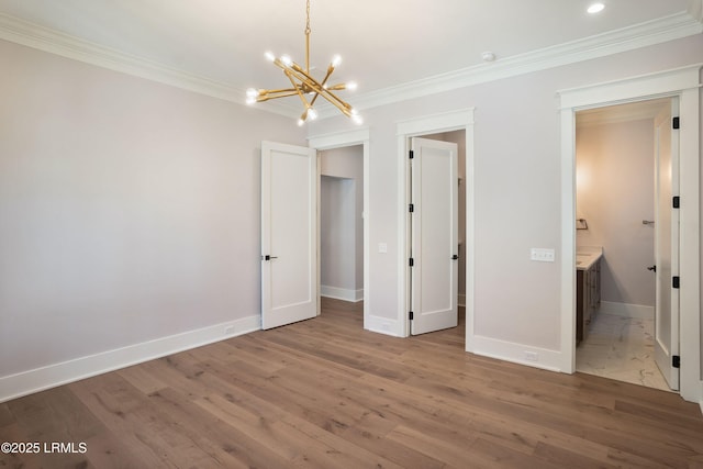 unfurnished bedroom featuring hardwood / wood-style floors, ornamental molding, and ensuite bathroom