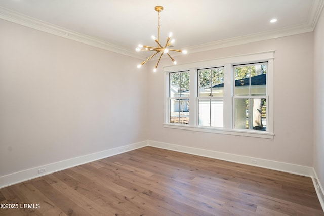 unfurnished room featuring wood-type flooring, crown molding, and a chandelier