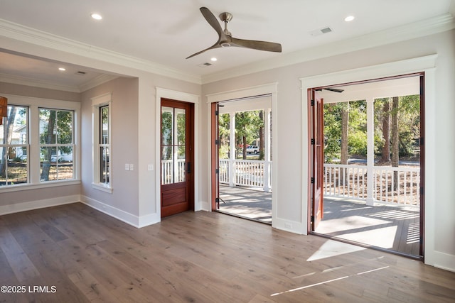 doorway featuring a wealth of natural light, ornamental molding, dark hardwood / wood-style floors, and ceiling fan