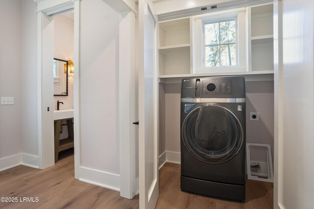 laundry area featuring sink, washer / dryer, and hardwood / wood-style floors