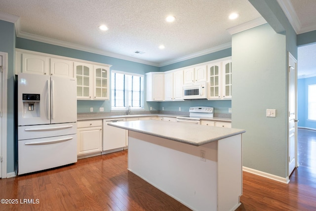 kitchen featuring crown molding, white appliances, white cabinets, and a kitchen island