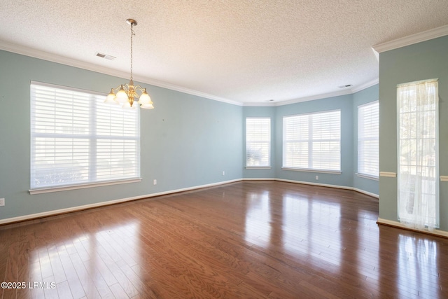 spare room with crown molding, dark hardwood / wood-style floors, a chandelier, and a textured ceiling