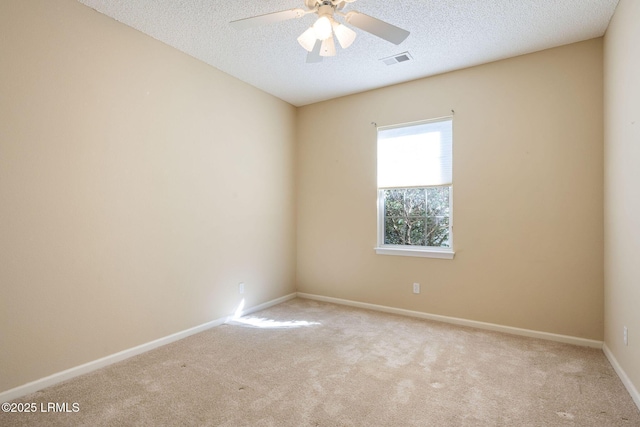 carpeted empty room with ceiling fan and a textured ceiling