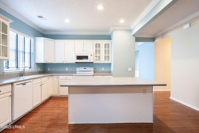 kitchen with sink, white appliances, a center island, and white cabinets