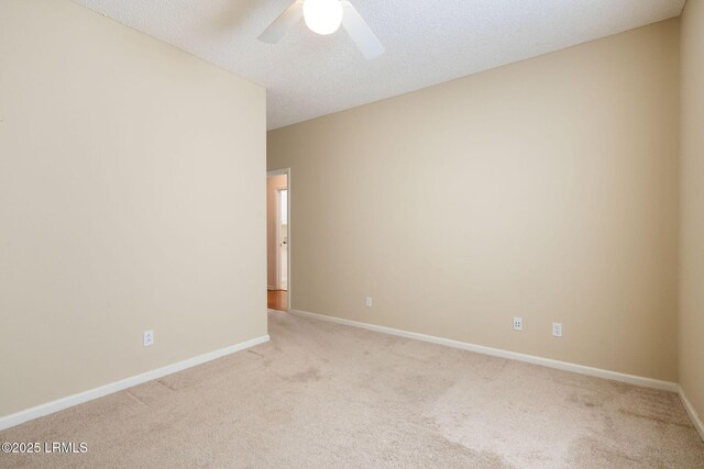 unfurnished room featuring ceiling fan, light colored carpet, and a textured ceiling