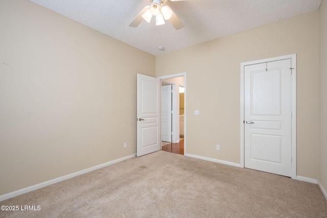 unfurnished bedroom with light colored carpet, a textured ceiling, and ceiling fan