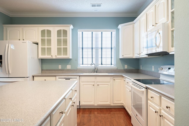 kitchen with sink, crown molding, dark hardwood / wood-style flooring, white appliances, and white cabinets