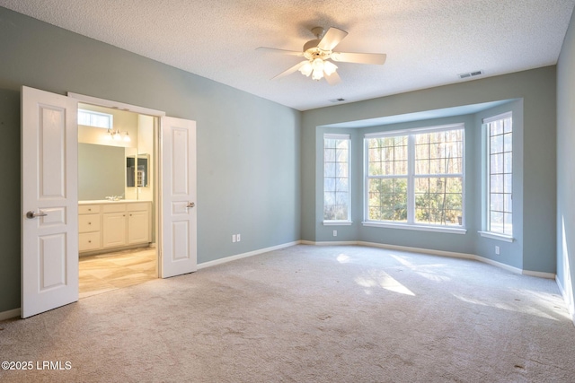 carpeted spare room with ceiling fan, sink, and a textured ceiling