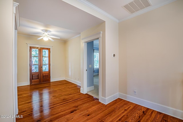 foyer entrance with crown molding, hardwood / wood-style flooring, a wealth of natural light, and french doors