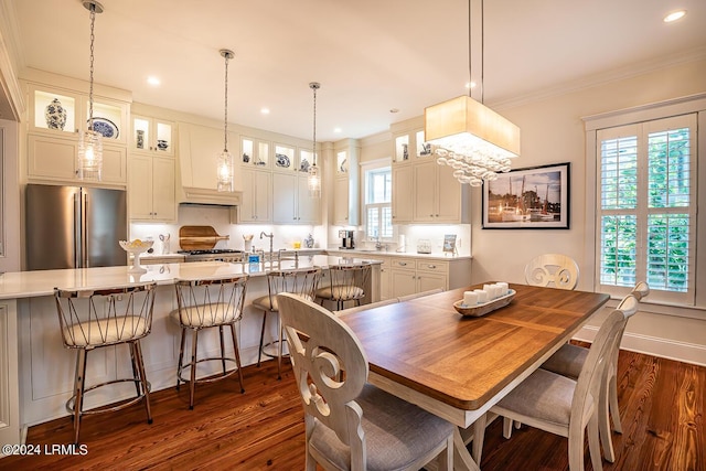 dining room with dark hardwood / wood-style flooring, crown molding, and a healthy amount of sunlight