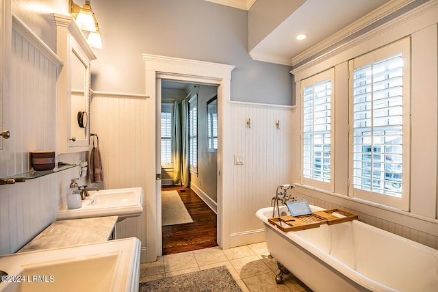 bathroom featuring ornamental molding, tile patterned flooring, and a washtub