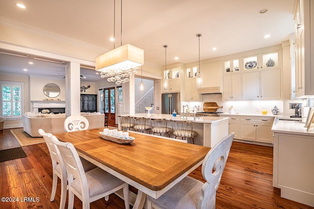 dining space with ornamental molding and dark hardwood / wood-style floors