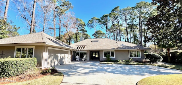 ranch-style home with driveway, an attached garage, and a shingled roof