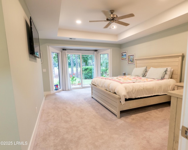 bedroom featuring recessed lighting, light carpet, access to exterior, baseboards, and a tray ceiling