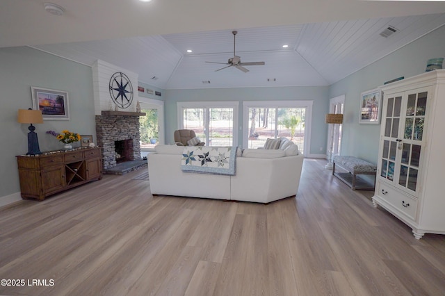 unfurnished living room featuring a stone fireplace, light wood-type flooring, visible vents, and baseboards