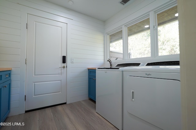 laundry area featuring visible vents, light wood-style floors, cabinet space, and washer and dryer