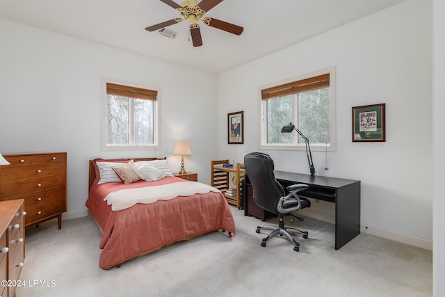 bedroom featuring multiple windows, ceiling fan, and light carpet