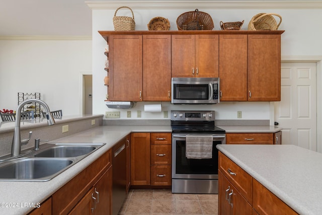 kitchen featuring crown molding, stainless steel appliances, sink, and light tile patterned floors