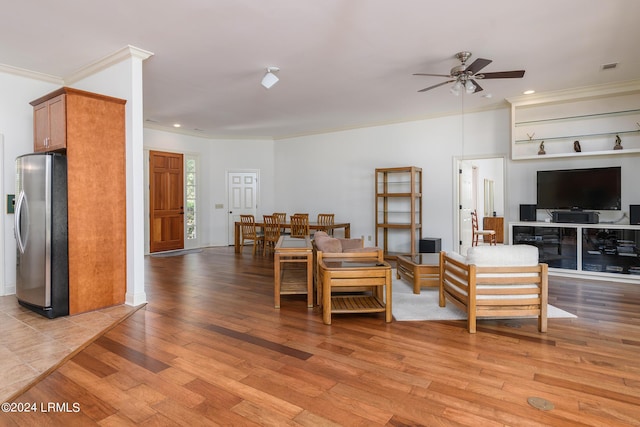 living room featuring crown molding, light hardwood / wood-style flooring, and ceiling fan