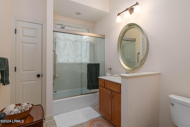 full bathroom with toilet, tile patterned floors, vanity, and bath / shower combo with glass door