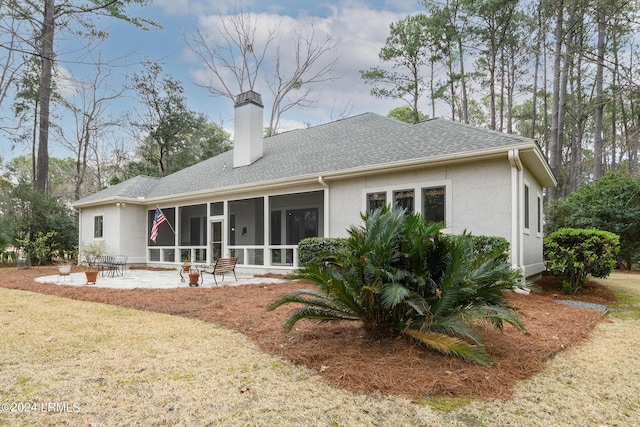 rear view of property featuring a sunroom, a yard, and a patio area