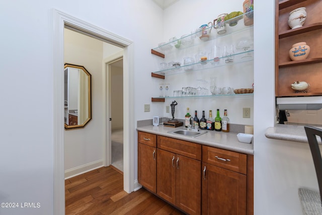 bar featuring sink and dark hardwood / wood-style floors