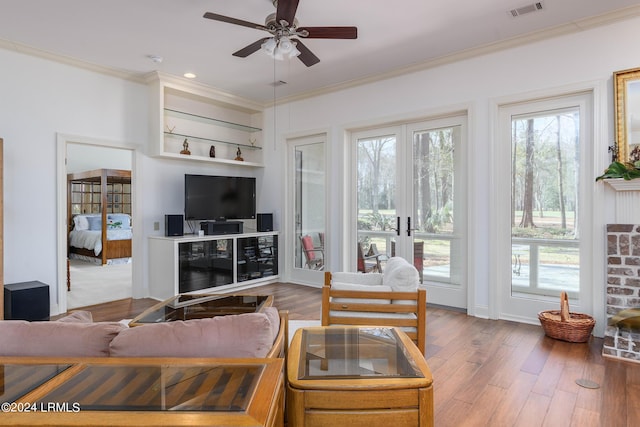 living room featuring hardwood / wood-style floors, ornamental molding, french doors, and ceiling fan