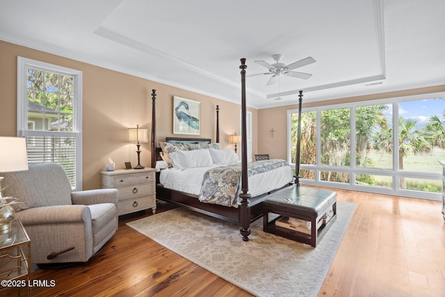 208 Cotton Dike Rd, Saint Helena Island, SC 29920 - bedroom featuring a tray ceiling, multiple windows, hardwood / wood-style floors, and crown molding