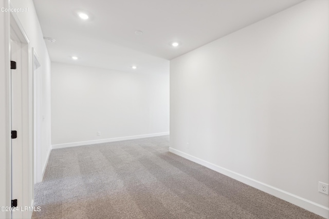 carpeted spare room featuring recessed lighting and baseboards