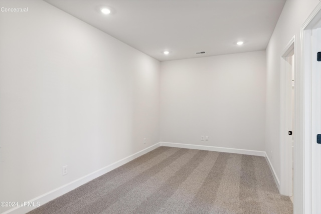 carpeted empty room with visible vents, baseboards, and recessed lighting