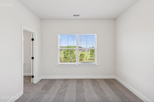 unfurnished room featuring carpet floors, baseboards, and visible vents