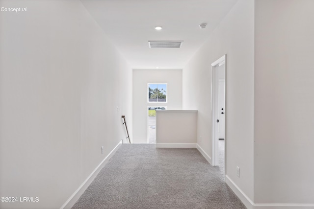 corridor featuring visible vents, carpet floors, an upstairs landing, and baseboards