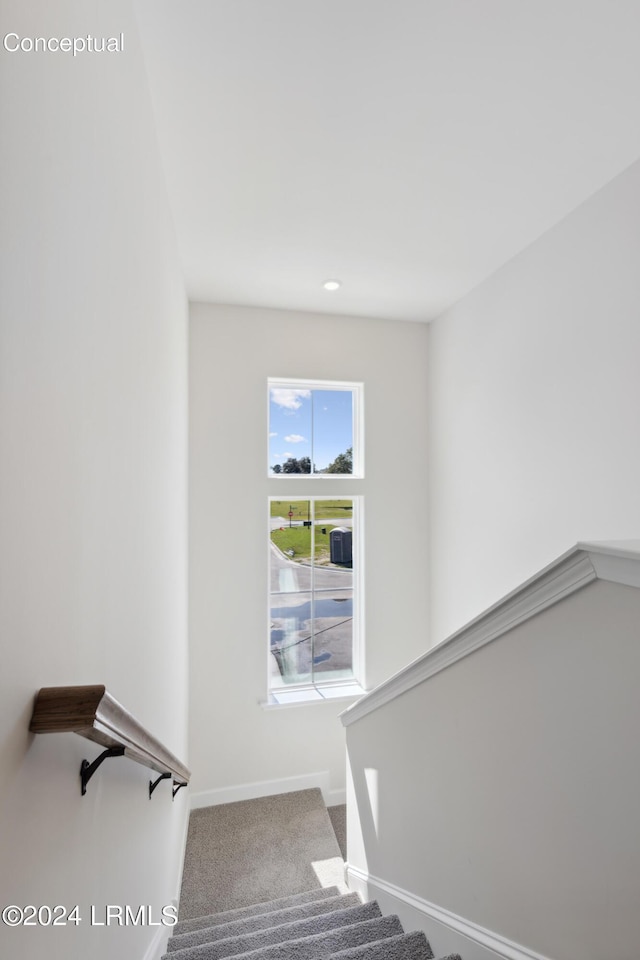 staircase featuring carpet and baseboards