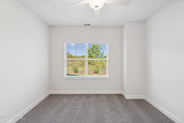 carpeted empty room with visible vents, baseboards, and ceiling fan