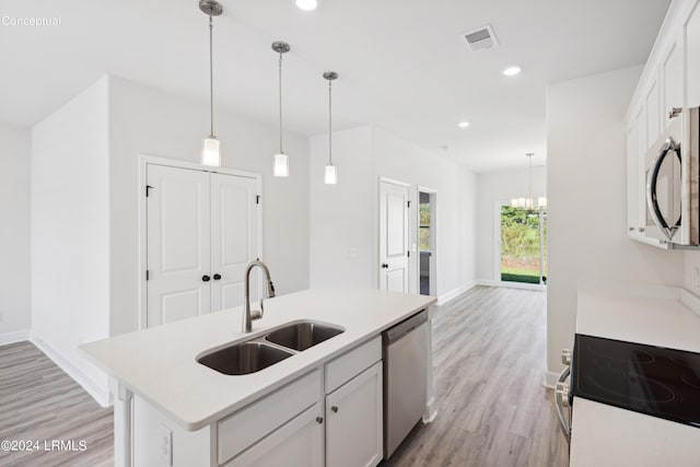 kitchen featuring light wood-style flooring, a sink, visible vents, light countertops, and appliances with stainless steel finishes