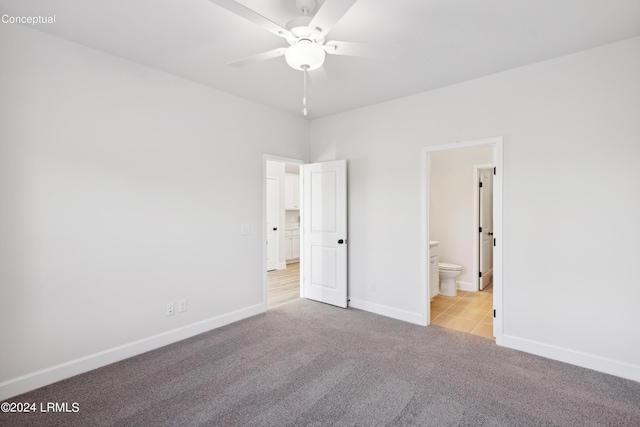 unfurnished bedroom featuring ensuite bath, carpet flooring, and baseboards