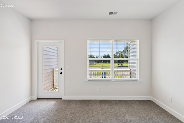 carpeted empty room with visible vents and baseboards