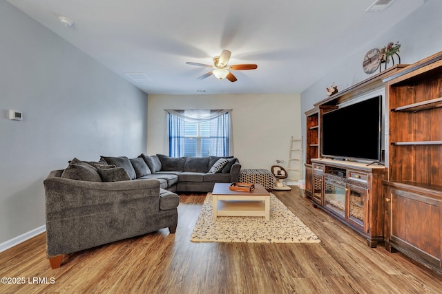 living room with wood-type flooring and ceiling fan