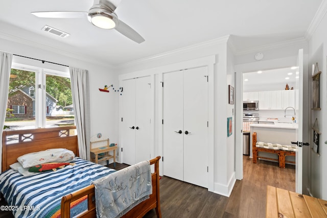 12 Harvest Ln, Beaufort, SC 29907 - bedroom featuring visible vents, ornamental molding, dark wood-type flooring, and two closets