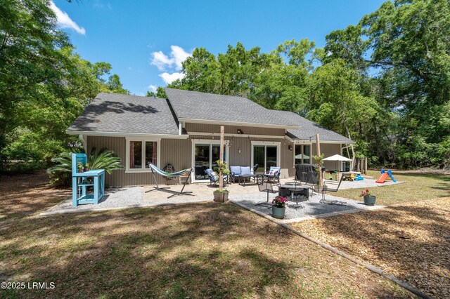 12 Harvest Ln, Beaufort, SC 29907 - rear view of property with a patio, a shingled roof, a playground, a lawn, and an outdoor fire pit