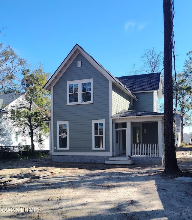 view of front facade featuring covered porch and a shingled roof