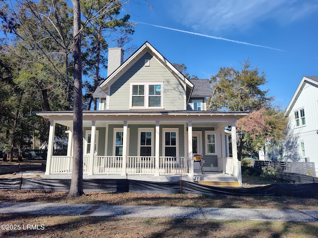 country-style home featuring a porch and a chimney