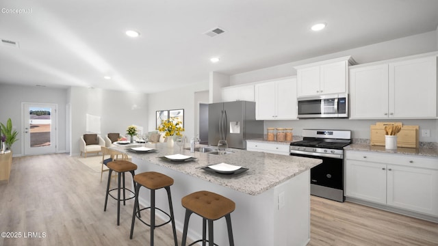 1533 Sanctum St, Ridgeland, SC 29936 - kitchen featuring stainless steel appliances, an island with sink, light wood finished floors, light stone countertops, and recessed lighting