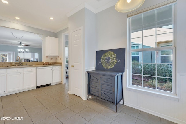 kitchen with sink, white cabinetry, crown molding, light tile patterned floors, and white dishwasher