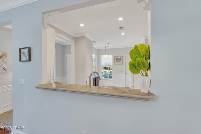 kitchen featuring sink, light tile patterned floors, ornamental molding, pendant lighting, and light stone countertops